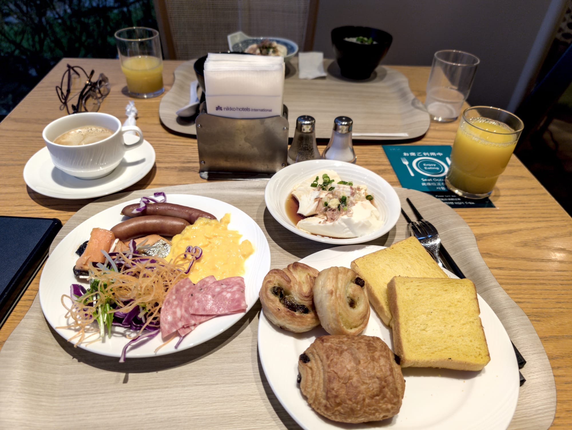 Breakfast plate with a variety of foods - tofu, pastries, eggs, sausage, salmon
